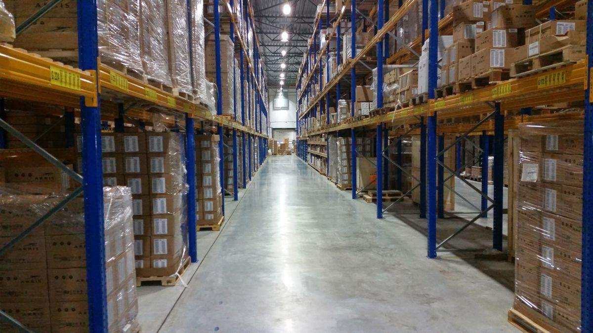 Corredor de estoque com pallets embalados em filme stretch